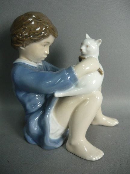 Girl grooming the white cat. Royal Copenhagen. Mar