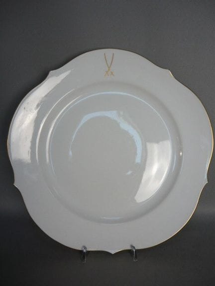 Large round plate with a golden sword logo. Meisse