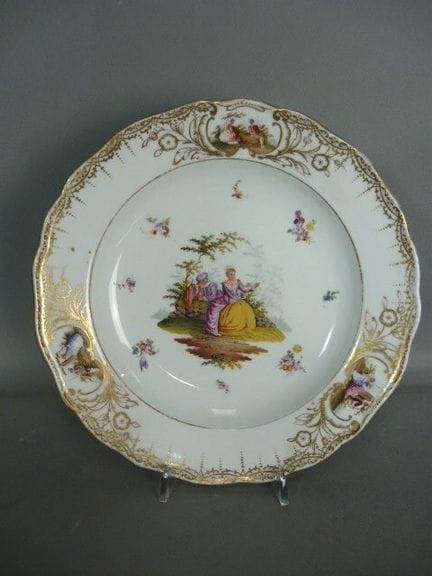 饰有洛可可风格场景、花卉及金饰的图案盘。迈森（施韦特）。1815-1924年印记。釉上多色手绘。二级