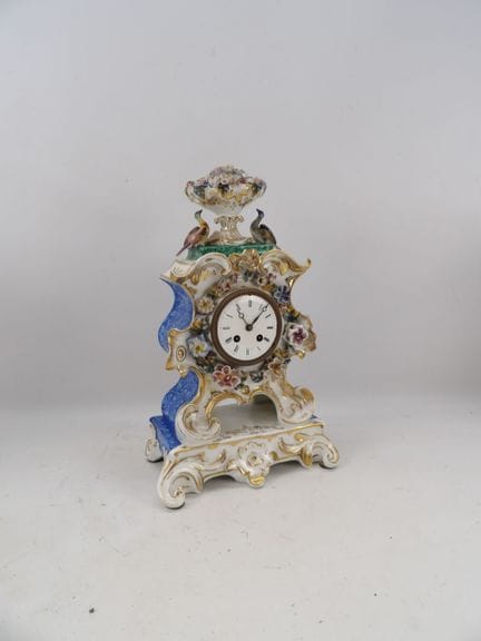 Polychrome porcelain mantel clock with floral reli