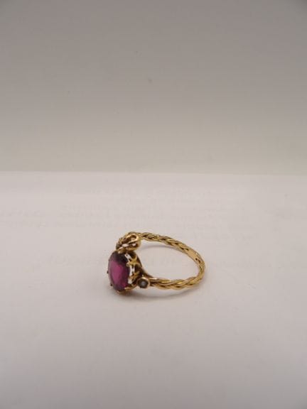 Anello in oro con pietre viola. Peso lordo: 2 g (t