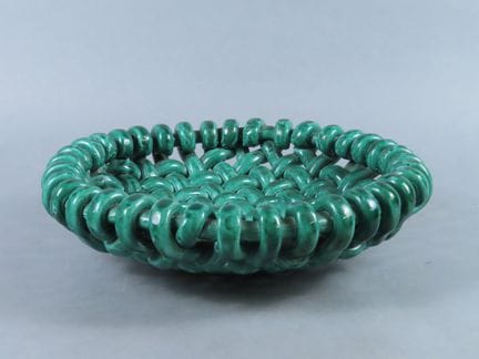 位于滨海阿尔卑斯省瓦洛里斯的杰罗姆·马西耶工坊。这件绿釉陶器呈圆形编织镂空造型，带底座。底座下方有印