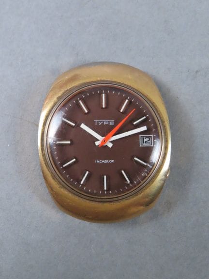 TYPE. Tonneau-shaped wristwatch case made of gold-