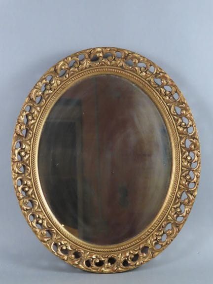 Miroir ovale  à cadre bois doré, le tain à patine 