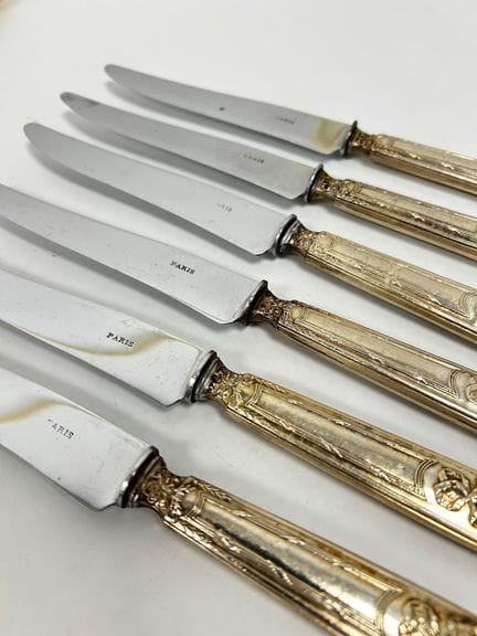 12 couteaux en argent fourré à décor de ruban et g