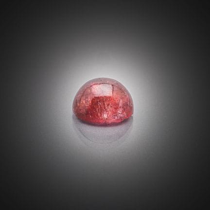 Tourmaline rose cabochon sur papier. 
Poids : 4,43