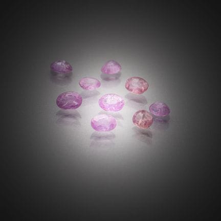 Lot de neuf saphirs roses ovales sur papier.
Poids