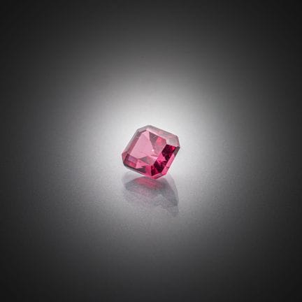 Grenat rhodolite rose violacé octogonal sur papier