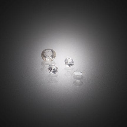 Lote de cuatro diamantes redondos sobre papel. 
Pe