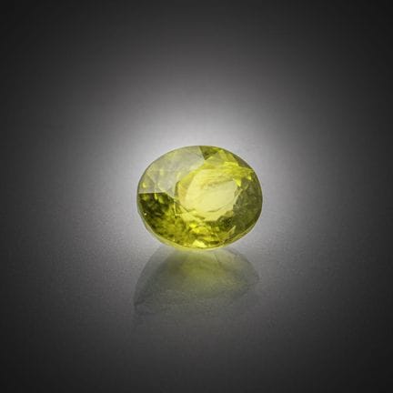 Péridot vert ovale sur papier.
Poids : 1,39 ct.