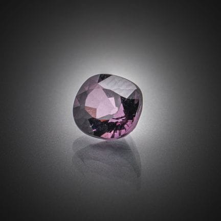 Espinela violeta de talla cojín sobre papel. 
Peso
