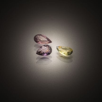 Set of three pear-shaped sapphires on paper. 
Vari