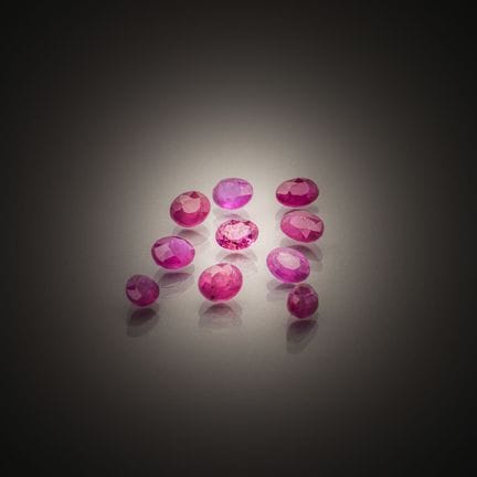 Set of ten oval rubies on paper.
Weight: 5.25 cts.