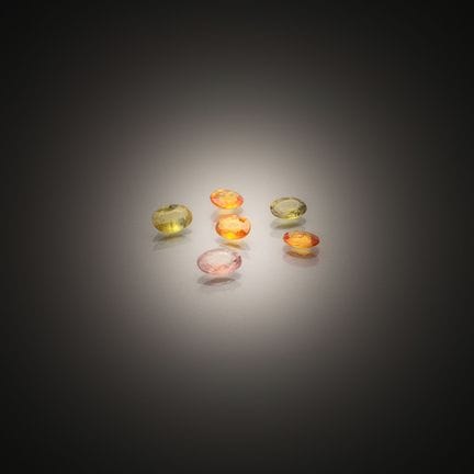 Set of six oval sapphires on paper.
Various colors