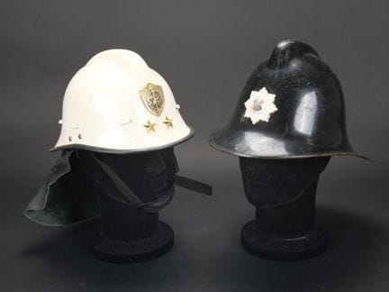 Zwei Feuerwehrhelme aus Fasermaterial mit Helmzier
