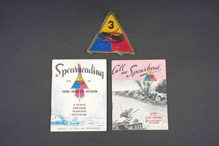 Booklets and insignia from the 3rd U.S. Armored Di