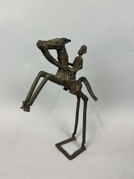 铜合金制骑手小雕像，表面呈深色包浆，刻画了一位骑在扬蹄骏马上的骑手，置于四边形底座上。
青铜骑手雕像