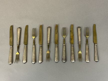 一套6件装甜点餐具，采用950千分之一纯银（米诺娃印记）与镀金的金属制成，装饰艺术风格
附带略有磨损
