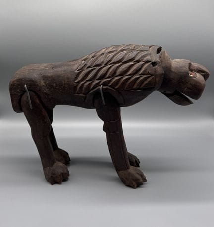 LION AUX MEMBRES ARTICULES 
Bois à patine sombre, 