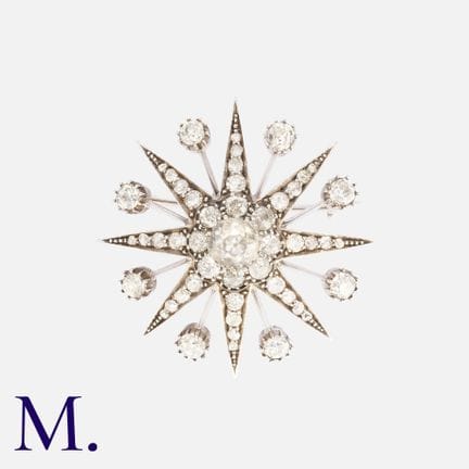 Une broche en forme d'étoile en or blanc, sertie d