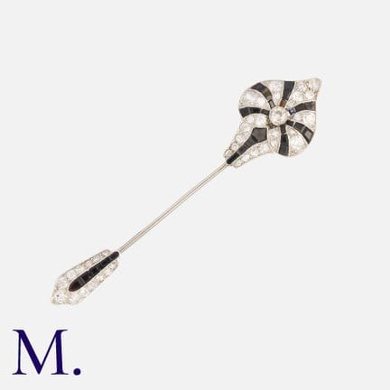 Une broche Art déco en onyx et diamants, en or jau