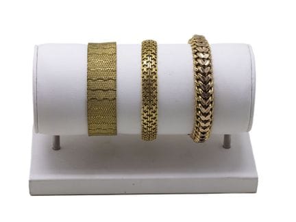 Tres pulseras articuladas de metal dorado, cierre 