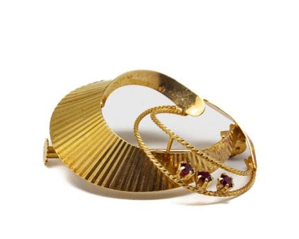 Broche en or jaune 18 K (750/1000) à décor de fris