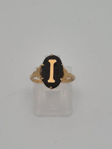 Bague en métal jaune sertie d'une pierre noire ova