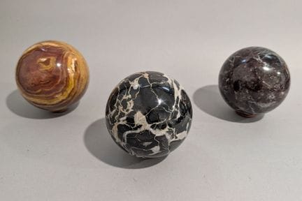 Suite de trois boules 
En marbre et jaspe
D.: 11 c