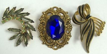 Three unique costume jewelry brooches from a liqui
