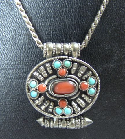 Necklace with a pendant set with turquoise and cor