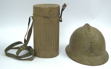 A steel helmet in heavily used condition and a gas