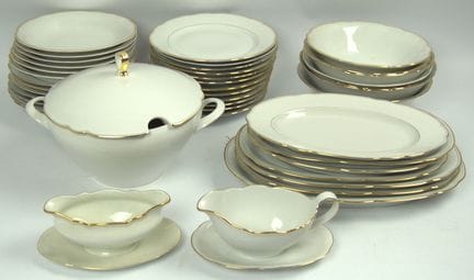 一套剩余的餐具，包括12个深盘、12个浅盘、7个大盘、7个碗、2个酱汁碗和1个带盖的炖锅。品牌各异，