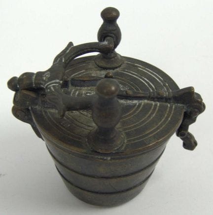 Antique bronze cup weight with four inserts.