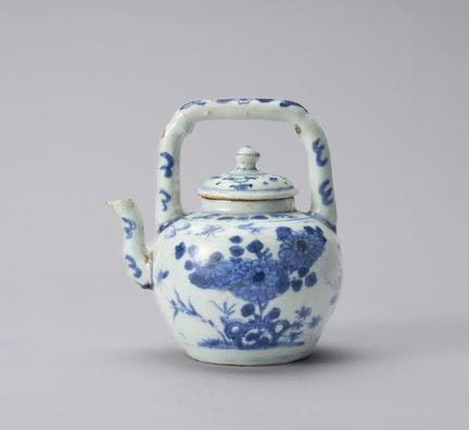 Una jarra antigua con motivos florales en azul y b