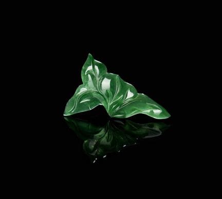 Una hoja de jadeíta. Una talla de jadeíta con form
