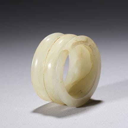 Un anillo de jade blanco y un soporte de palisandr