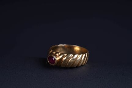 18K yellow gold (750) band ring featuring a ruby s