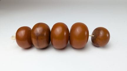 CINQ PERLES D'AMBRE montées en collier.
Long. 16 c