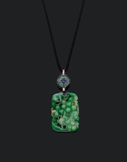 CARTIER. 
A black cord suspending an oval pendant 