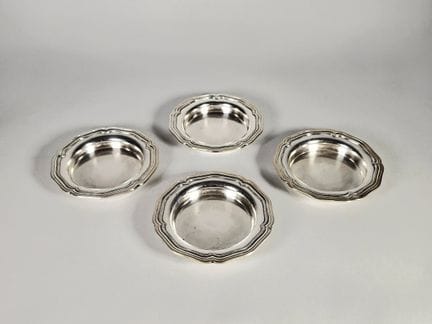 Set of four bottle coasters with scalloped edges. 