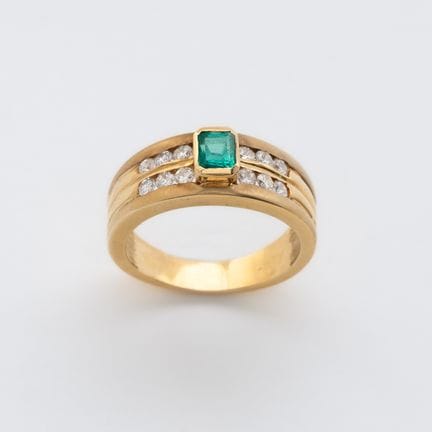 Ring in gold with octagonal cut emerald guarded by