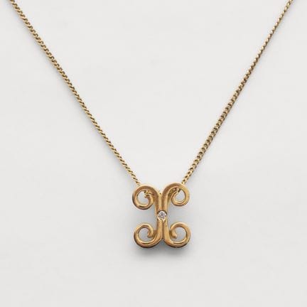 Beaded chain with a scroll-motif pendant and a cen