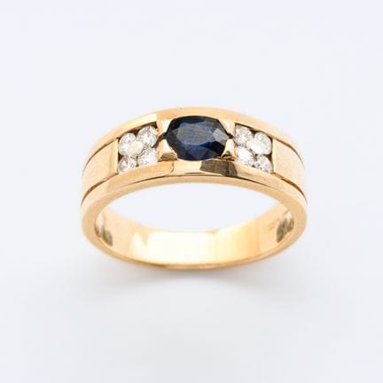 Ring in gold with oval cut blue sapphire guarded b