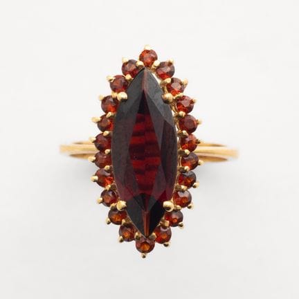 Gold slide ring with prong-set garnets; the center