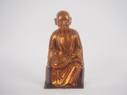 印度支那，约1900年
漆木鎏金小雕像，刻画了一位手持书籍的坐姿年轻僧人。
高34厘米