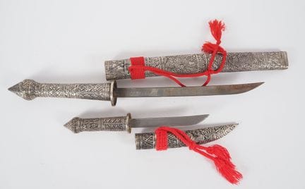 缅甸，约1900年
两把带银制刀鞘的匕首，表面以浮雕技法饰有人物、动物及花卉图案。
长55厘米和32
