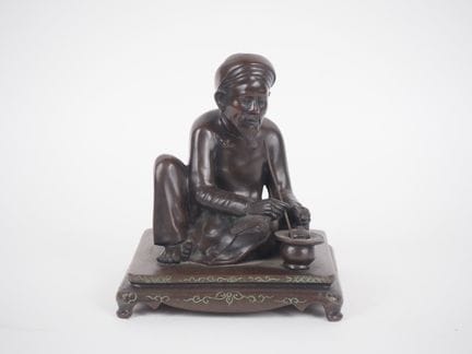 印度支那，约1920年，
青铜群像，描绘了一位蹲坐的吸烟者。
高23厘米，底座尺寸28.5×27厘米