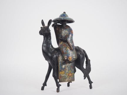日本，约1900年
青铜与镂空珐琅组合雕塑，描绘了托巴骑在骡子上的场景。
高40厘米
（有氧化痕迹）