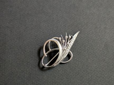 SPILLA "voluta" in oro bianco (750‰) traforata e f